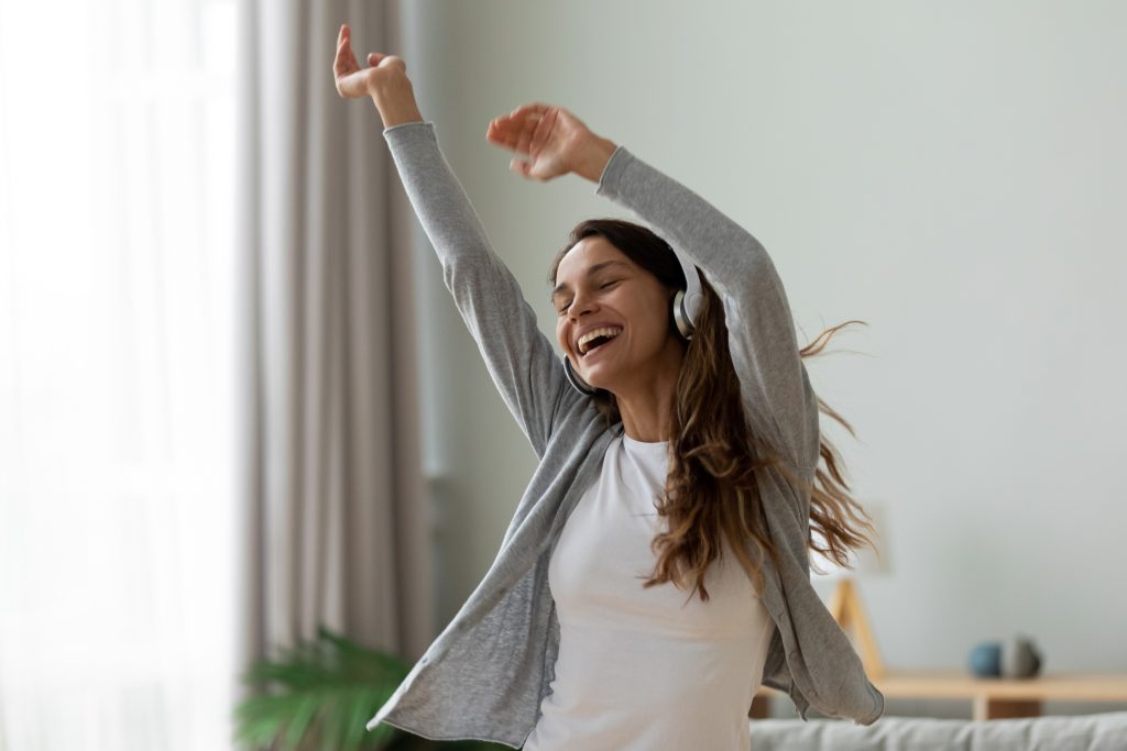 The Top 3 Essentials to Balance Hormones Naturally | balance hormones naturally carefree happy woman raised hands dancing wearing headphones listening favourite song balance hormones naturally - carefree happy woman raised hands dancing wearing headphones listening favourite song