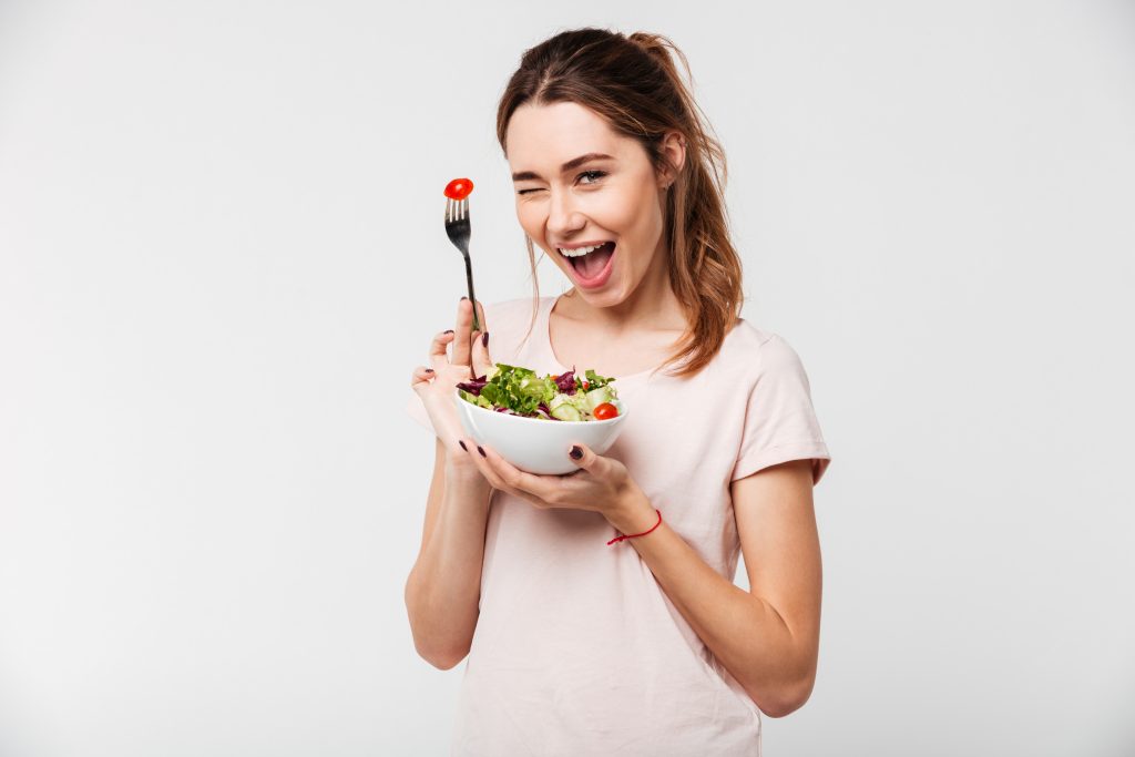 The Top 3 Essentials to Balance Hormones Naturally | balance hormones naturally girl eating fresh salad from a bowl and winking 1 balance hormones naturally - girl eating fresh salad from a bowl and winking