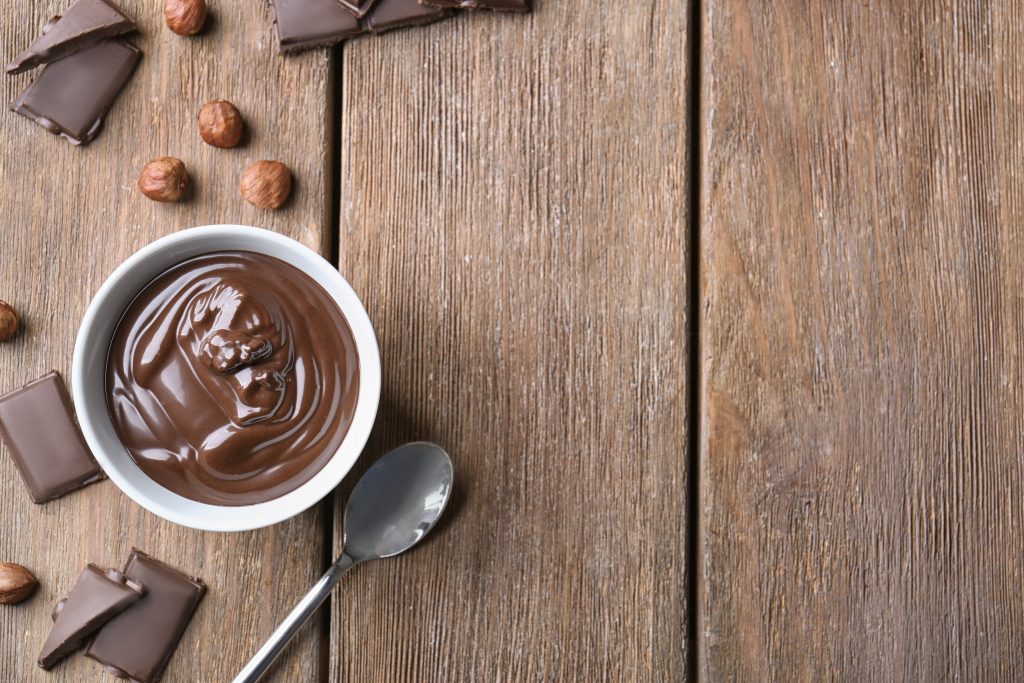 The Best Coffee Alternatives for a Healthy Gut, Balanced Hormones & More Energy (My Top “Gut Luv Coffee” Picks!) | best coffee alternatives Bowl with delicious chocolate sauce spoon and nuts on wooden table best coffee alternatives - Bowl with delicious chocolate sauce, spoon and nuts on wooden table