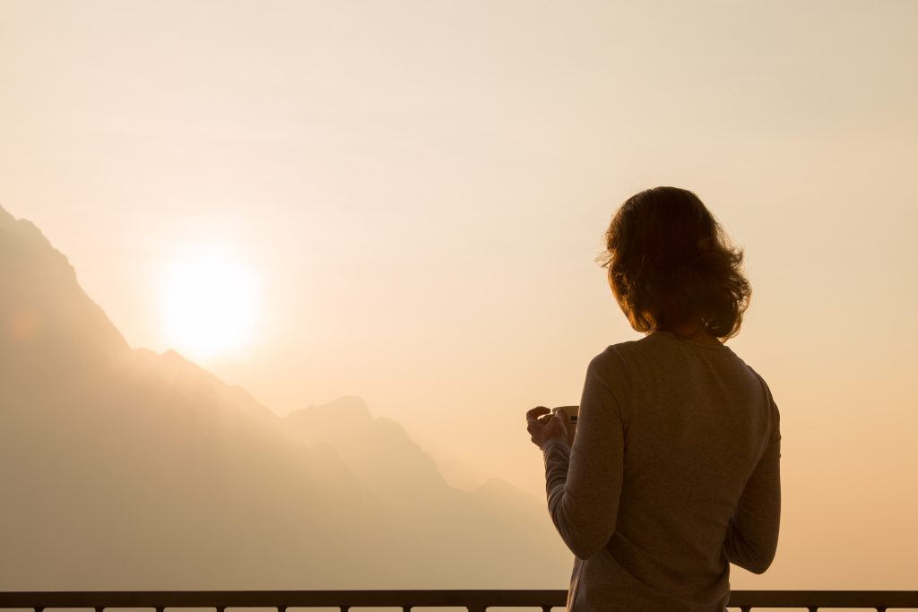 5 Best Holistic Cancer Recovery Strategies: A Functional Medicine Approach | holistic cancer recovery strategies girl starting new day enjoying morning coffee looking at peaceful serene sunrise on morning sky holistic cancer recovery strategies - girl starting new day enjoying morning coffee looking at peaceful serene sunrise on morning sky