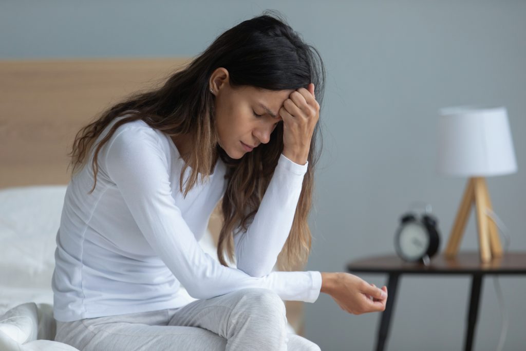 Get Rid of a UTI Fast: 10 Quick Natural UTI Remedies (No Antibiotics Included) | natural UTI remedies woman sitting on bed feeling depressed thinking about problems natural UTI remedies - woman sitting on bed, feeling depressed, thinking about problems