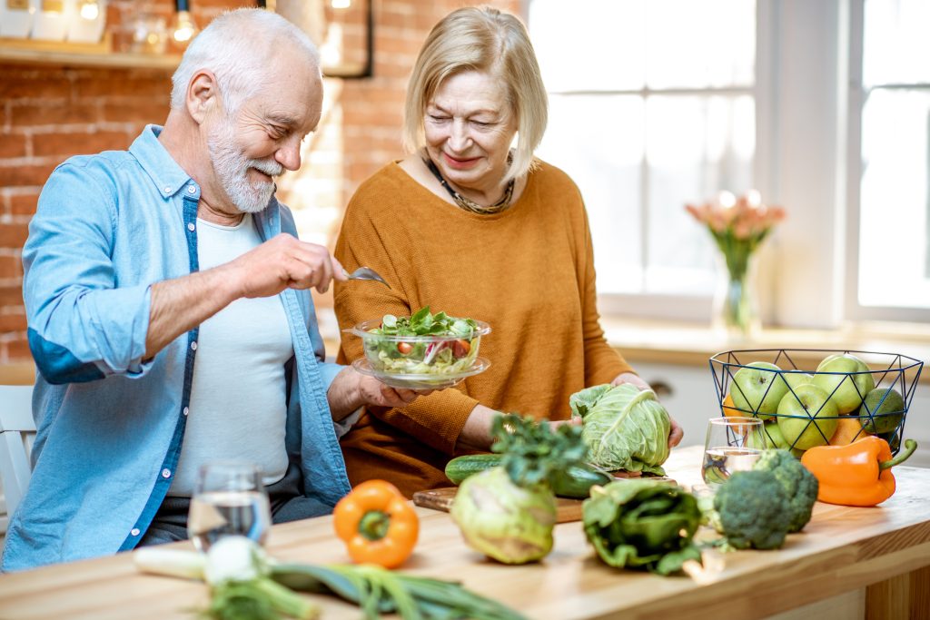 What is Functional Medicine? 10 Benefits of Functional Medicine for Your Health Goals | functional medicine senior couple eating salad standing together with healthy food on the kitchen at home functional medicine - senior couple eating salad standing together with healthy food on the kitchen at home