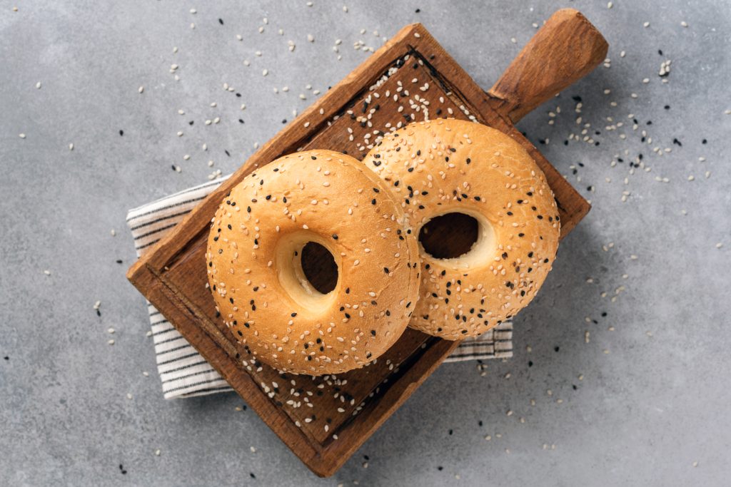 Have You Accidentally Eaten Foods That Cross-React with Gluten? Avoid These Top 10 Triggers | foods that cross react with gluten Two sesame bagels on wooden cutting board foods that cross-react with gluten - Two sesame bagels on wooden cutting board