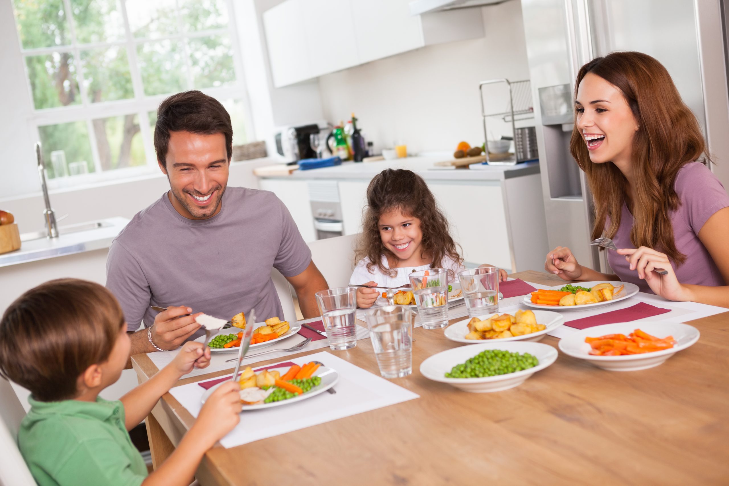 Eat for Your Gut Type: 8 Strategies to Boost Digestion Naturally | Strategies to Boost Digestion Family laughing around a good meal in kitchen scaled Strategies to Boost Digestion - Family laughing around a good meal in kitchen