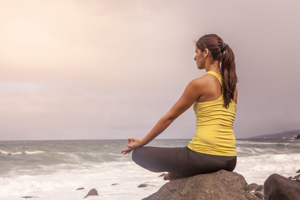 The Ultimate Guide to Gut Health + 3 Essentials to Heal Your Gut | gut health young woman practicing yoga meditation on the beach at sunset gut health - young woman practicing yoga meditation on the beach at sunset
