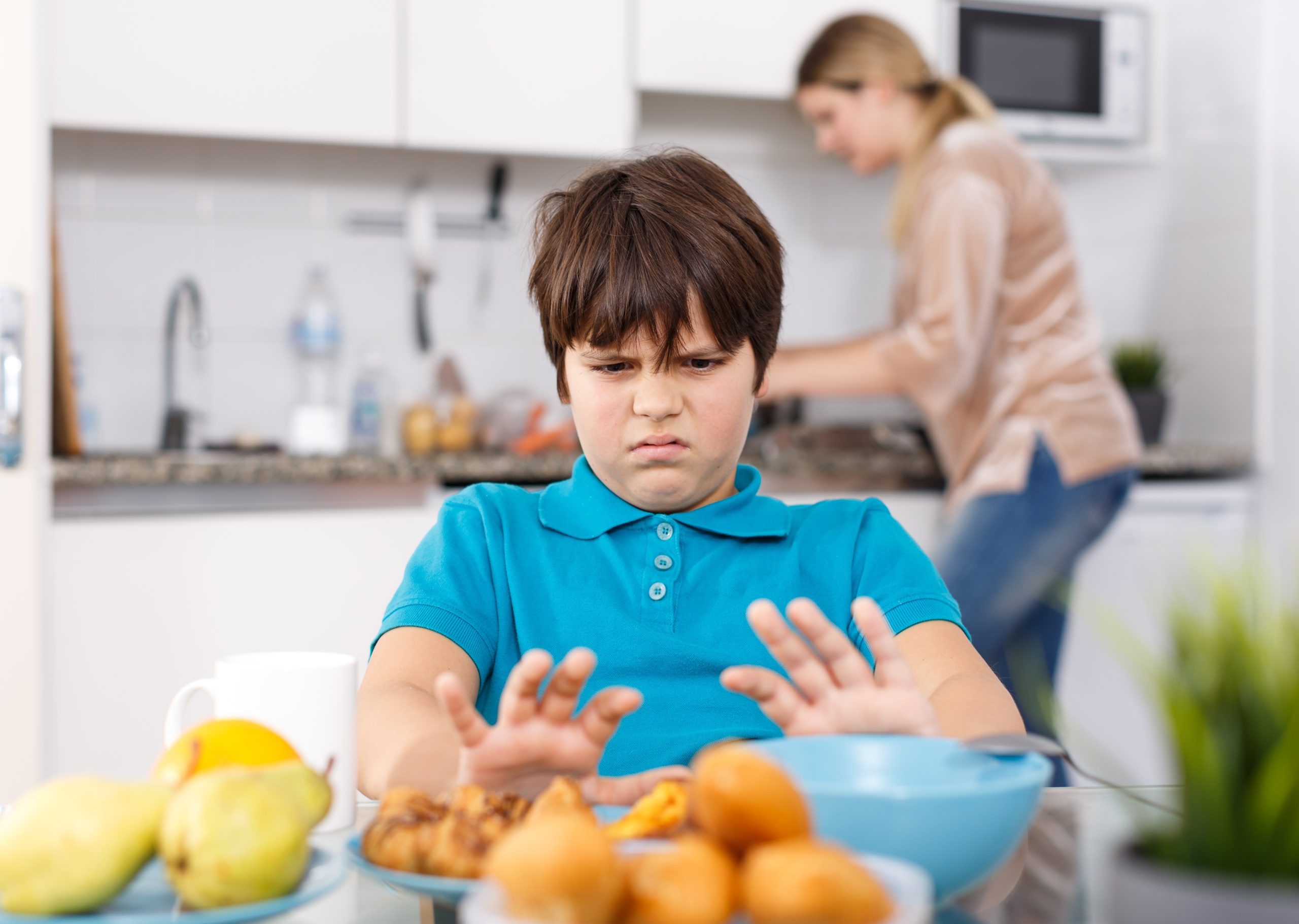 3 Easy Hacks to End Picky Eating And How to Help Your Kids to Eat Healthier | picky eating school age boy sitting at kitchen table do not want to eat scaled picky eating - school age boy sitting at kitchen table do not want to eat