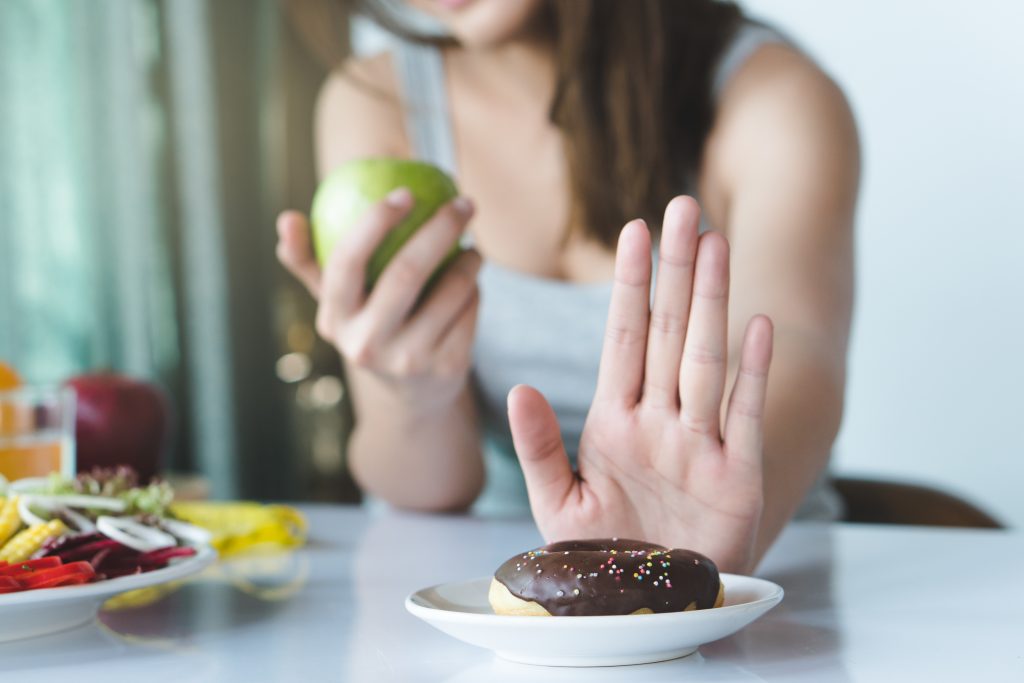 Natural Gallbladder Cleanse: Cholagogue Foods And 13 Total Lifestyle Strategies for Improving Gallbladder Health | natural gallbladder cleanse female using hand push out her favourite donut and choose green apple and vegetables for good health natural gallbladder cleanse - female using hand push out her favourite donut and choose green apple and vegetables for good health