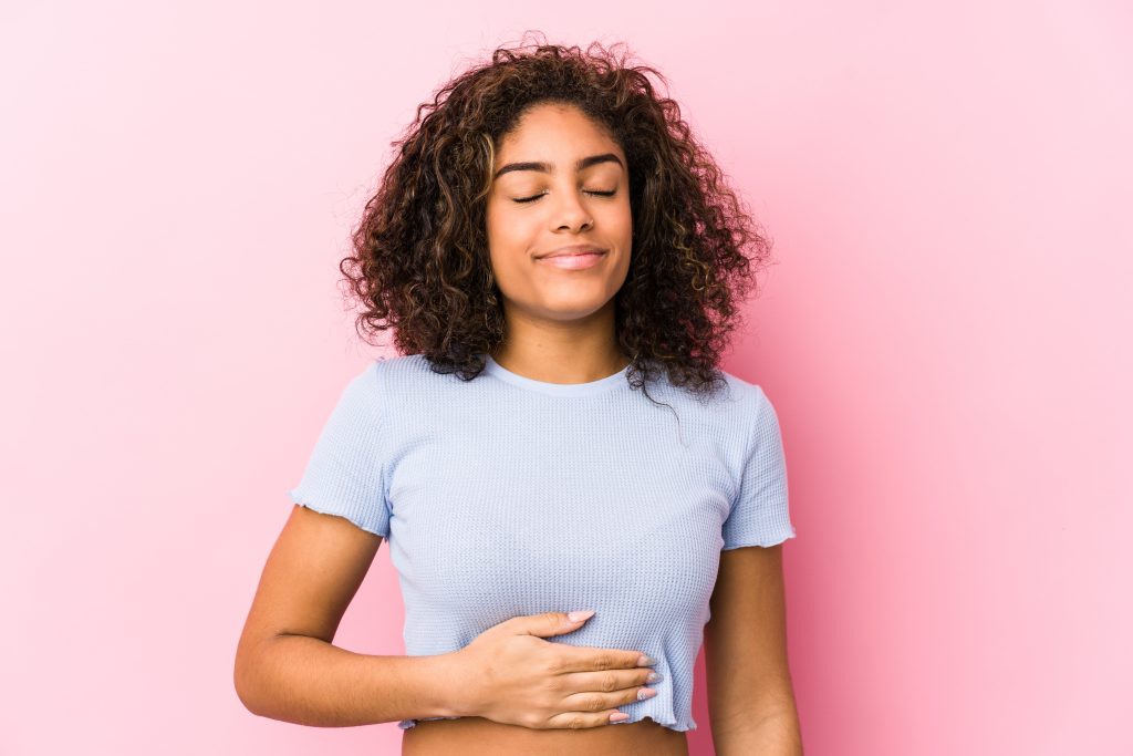Natural Gallbladder Cleanse: Cholagogue Foods And 13 Total Lifestyle Strategies for Improving Gallbladder Health | natural gallbladder cleanse woman touches tummy smiles gently eating and satisfaction natural gallbladder cleanse - woman touches tummy, smiles gently, eating and satisfaction