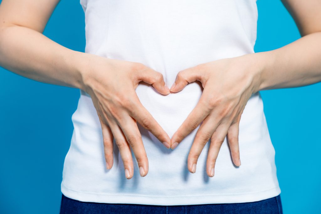 Why Do I Feel Like This? A Total Gut-Brain Reset Journey | total gut brain reset young woman who makes a heart shape by hands on her stomach total gut-brain reset - young woman who makes a heart shape by hands on her stomach